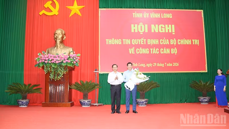 Đồng chí Nguyễn Mạnh Hùng nhận hoa chúc mừng của đồng chí Trần Văn Lâu, Ủy viên Trung ương Đảng, Bí thư Tỉnh ủy Vĩnh Long.