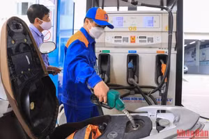 Nhân viên bơm xăng cho khách hàng tại một cửa hàng kinh doanh xăng dầu. (Ảnh: THÀNH ĐẠT)