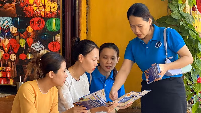 Cán bộ Bảo hiểm xã hội tuyên truyền chính sách bảo hiểm xã hội, bảo hiểm y tế cho người lao động phường Hội An (tỉnh Quảng Nam).