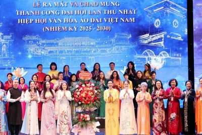 Chủ tịch Hiệp hội Văn hóa Áo dài Đặng Thị Bích Liên cùng thành viên Hiệp hội nhận hoa chúc mừng từ các đại biểu. (Ảnh: Ban tổ chức cung cấp)