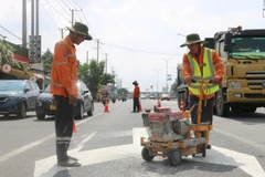 Công nhân sơn kẻ vạch đường trên Quốc lộ 51. 