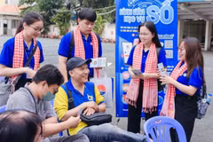 Sinh viên Học viện Cán bộ Thành phố Hồ Chí Minh trao đổi, hướng dẫn người dân đến giao dịch hành chính tại Ủy ban nhân dân phường Bình Thạnh.