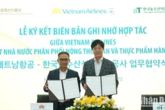 Ông Lê Minh Tuấn, Phó trưởng ban Dịch vụ Hành khách (Vietnam Airlines) và ông Kim Kyoung Cheol, Giám đốc khu vực ASEAN (aT) trao biên bản hợp tác.