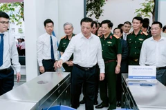 Bộ trưởng Xây dựng Trần Hồng Minh sử dụng thẻ đi tàu thông minh trong phòng mô phỏng tại UTH. (Ảnh: UTH)