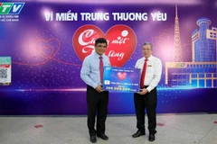Ông Nguyễn Văn Thanh, Tổng Giám đốc EVNHCMC (áo trắng) trao bảng tượng trưng số tiền 200 triệu ủng hộ Quỹ “Chung một tấm lòng: Vì miền trung thương yêu”.