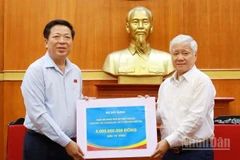 Bộ trưởng Xây dựng Trần Hồng Minh (trái) trao 5 tỷ đồng ủng hộ đồng bào lũ lụt qua Ủy ban Trung ương Mặt trận Tổ quốc Việt Nam.