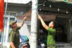 Cán bộ, chiến sĩ Công an Thành phố Hồ Chí Minh tham gia bóc xóa quảng cáo trái quy định.
