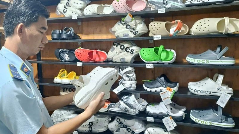 Lực lượng Quản lý thị trường Thành phố Hồ Chí Minh kiểm tra dép có dấu hiệu giả mạo nhãn hiệu tại một hộ kinh doanh.