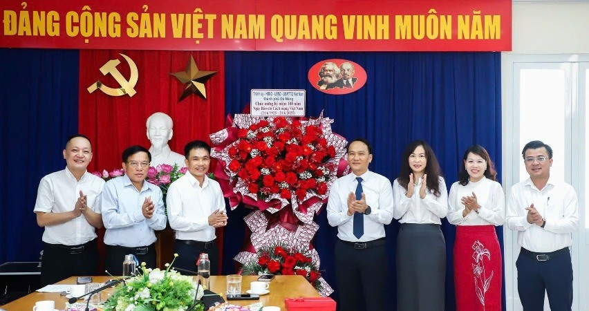 Phó Bí thư Thường trực Thành ủy Nguyễn Đình Vĩnh thay mặt Thành ủy, Hội đồng nhân dân, Ủy ban nhân dân, Ủy ban Mặt trận Tổ quốc Việt Nam thành phố Đà Nẵng tặng hoa chúc mừng.