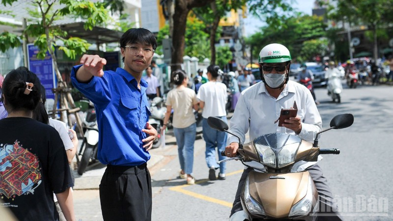 Tình nguyện viên hỗ trợ phân luồng đảm bảo an toàn giao thông tại điểm thi. ndo_br_71d3114a-2bf7-4d84-99db-cb7a18e20ead-2214.jpg