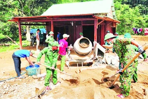 Cán bộ, chiến sĩ Đồn Biên phòng Đắc Pring giúp người dân vùng biên xây dựng nhà mới.