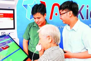 Người dân trải nghiệm thiết bị “AI Kiosk” trong Ngày Chuyển đổi số quốc gia năm 2025 tại phường Chợ Quán. (Ảnh CTV)