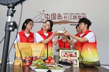 Sinh viên tình nguyện của Học viện Tài chính-Kinh tế Trùng Khánh, Trung Quốc live stream giới thiệu sản phẩm địa phương. (Ảnh: Tân Hoa Xã)