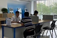 Người dân làm thủ tục hành chính tại Trung tâm phục vụ hành chính công thành phố Hà Nội, chi nhánh số 1. (Ảnh: DIỆU THƯƠNG)