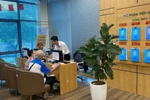 Người dân làm thủ tục hành chính trực tuyến tại Trung tâm phục vụ hành chính công thành phố Hà Nội, chi nhánh số 3. (Ảnh: DIỆU THƯƠNG)