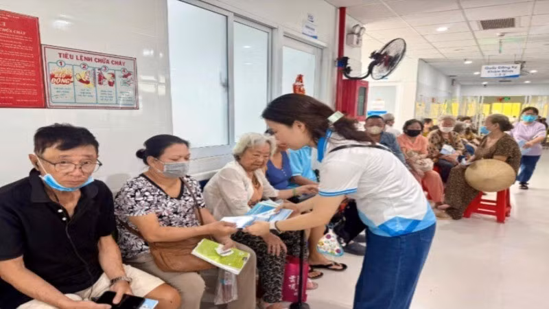 Nhân viên Bảo hiểm Xã hội tư vấn về chính sách khám chữa bệnh Bảo hiểm y tế. (Ảnh: QUÝ HIỀN)