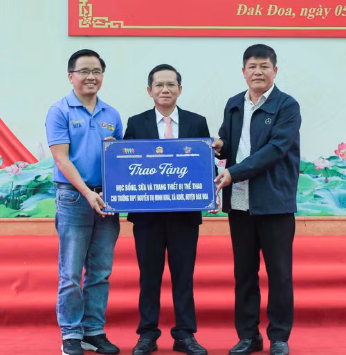 Ông Nguyễn Tấn Anh cùng ông Y Đức Thành trao các phần quà đến đại diện trường