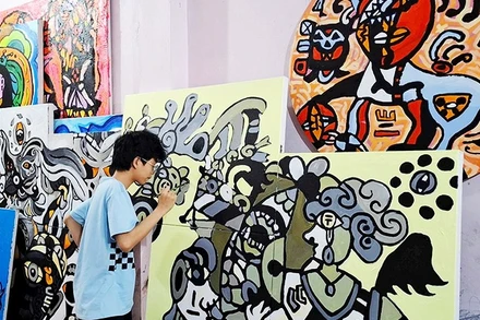 Hoàng Nhật Quang bên tác phẩm của mình.