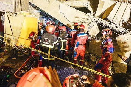 Lực lượng cứu hộ tìm kiếm người mất tích. Ảnh: AP