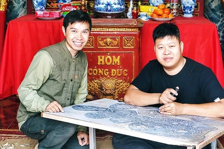 Anh Ngô Quý Đức (bên trái) kiểm tra quy trình tạo tác liễn làng Chuồn.