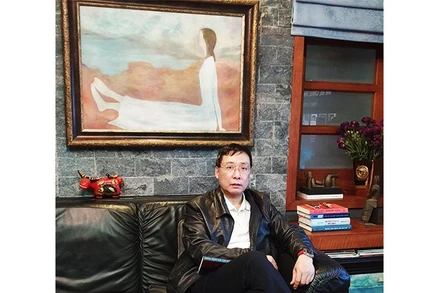 Nhà sưu tầm Hoàng Anh Tuấn bên tác phẩm của họa sĩ Dương Bích Liên.