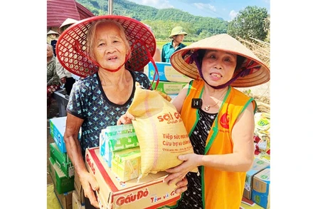 Bà Nguyệt đi phát gạo cho người dân vùng ngập nước.