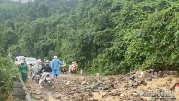 Nước mưa đã cuốn phăng đất, đá từ ta-luy trên cao tràn xuống mặt đường, gây mất an toàn giao thông, cản trở việc đi lại của người dân. (Ảnh: VŨ TÂN)