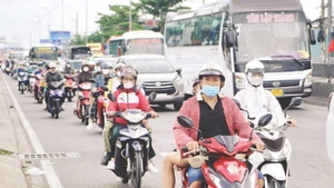 Xe gắn máy lưu thông trên các tuyến quốc lộ cửa ngõ ra vào Thành phố Hồ Chí Minh. (Ảnh THẾ ANH)