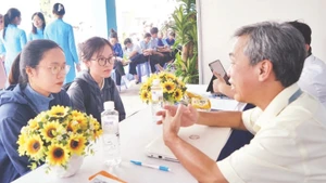 Các sinh viên mới ra trường được tư vấn tại ngày hội việc làm. (Ảnh THẾ ANH)