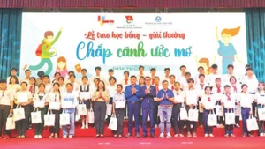 Các em học sinh có hoàn cảnh khó khăn nhận học bổng "Chắp cánh ước mơ" . (Ảnh DŨNG NHÂN)