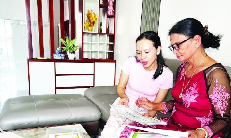 Bà Dư Thị Ánh (68 tuổi) bên những tấm bằng khen, giấy chứng nhận thành tích học tập của con cháu được gìn giữ cẩn thận.