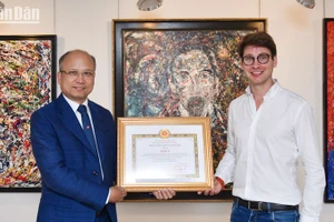Đại sứ Đinh Toàn Thắng trao bằng chứng nhận Giải A cho họa sĩ Georg Esco. (Ảnh: MINH DUY)
