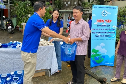 Công ty Cổ phần Cấp nước Gia Định cùng người dân diễn tập cấp nước an toàn nhằm ứng phó sự cố bể ống cấp nước tại lô I, II cư xá Thanh Đá, phường Bình Quới. (Ảnh: QUÝ HIỀN)