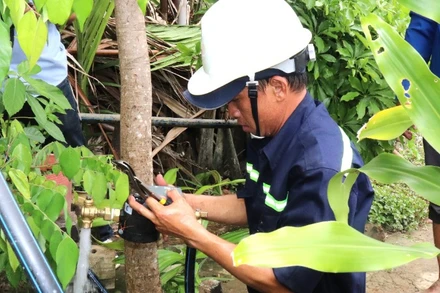 Nhân viên Xí nghiệp Cấp nước Cần Giờ gắn đồng hồ nước tại cù lao Mỹ Khánh để bảo đảm duy trì cung cấp nước sạch liên tục cho người dân. (Ảnh: QUÝ HIỀN)