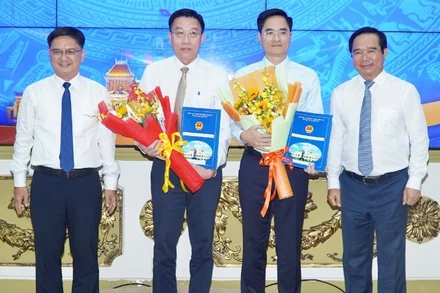 Ông Trần Quang Lâm nhận quyết định làm Giám đốc Sở Xây dựng Thành phố Hồ Chí Minh và ông Nguyễn Anh Minh (thứ hai từ trái qua) nhận quyết định làm Giám đốc Ban Quản lý dự án đầu tư xây dựng các công trình giao thông Thành phố Hồ Chí Minh 