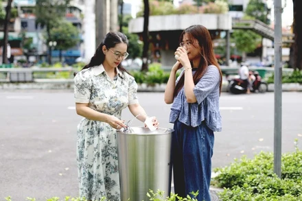 Các bạn trẻ sử dụng trụ nước uống tại vòi đặt ở Khu vực Hồ Con Rùa. (Ảnh: QUÝ HIỀN)