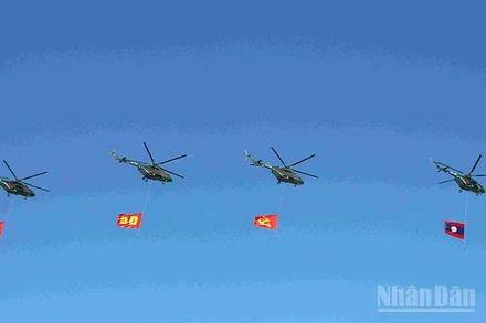 Đội hình máy bay trực thăng mang cờ Đảng, cờ Tổ quốc Lào trên bầu trời quảng trường That Luang. (Ảnh: DUY TOÀN)
