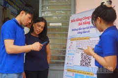 Thanh niên tình nguyện hướng dẫn người dân cài đặt ứng dụng Danang smart city.