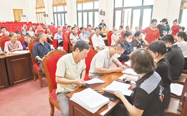 Người dân xã Đắc Sở, huyện Hoài Đức nhận tiền hỗ trợ giải phóng mặt bằng dự án đường vành đai 4-Vùng Thủ đô. (Ảnh Duy Linh)