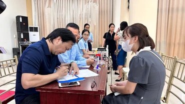 Cán bộ quận Thanh Xuân hướng dẫn, hỗ trợ người dân làm thủ tục nhận tiền hỗ trợ.