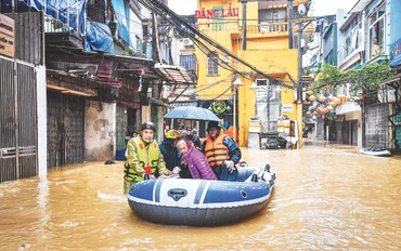 Lực lượng chức năng ứng cứu, giúp người dân khu vực phường Phúc Tân (quận Hoàn Kiếm, Hà Nội) di chuyển đến nơi an toàn khi nước lũ lên nhanh, nhiều khu vực bị ngập sâu. Ảnh: Thành Đạt