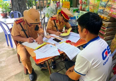 Cảnh sát giao thông Lào Cai lập biên bản xử phạt và tước giấy phép lái xe đối với tài xế và chủ doanh nghiệp "đội lốt" xe khách tuyến cố định. (Ảnh: QUỲNH TRANG)