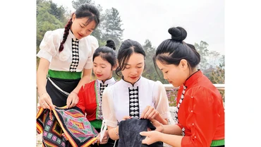 Học sinh dân tộc Thái, Khơ Mú ở huyện Sốp Cộp thêu khăn piêu và hoa văn bằng chỉ mầu trên vải truyền thống.