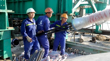 Công nhân lắp đặt thiết bị thông tin tại Nhà máy đóng tàu Hồng Hà (Hải Phòng). (Ảnh ANH SƠN)