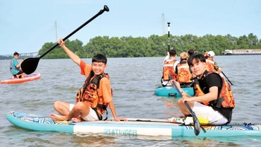 Du khách trải nghiệm chèo SUP trên sông Hậu. 