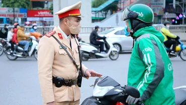 Cảnh sát giao thông Hà Nội nhắc nhở lái xe công nghệ chấp hành nghiêm Luật Giao thông đường bộ. (ảnh HUY HOÀNG)
