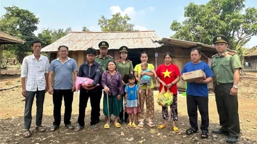 Lực lượng công an trao các nhu yếu phẩm tặng gia đình ông Vương Văn Long sau khi hồi hương. (Ảnh HỒNG LONG)