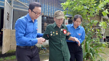 Các cán bộ đoàn đưa cựu chiến binh Nguyễn Phương Ðàn (99 tuổi, trú phường Noong Bua, thành phố Ðiện Biên Phủ, tỉnh Ðiện Biên) đi thăm lại chiến trường năm xưa.