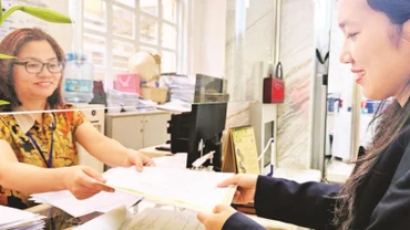 Chị Phạm Thị Trúc (ngụ phường Hiệp Bình Chánh, thành phố Thủ Đức) nhận Giấy chứng nhận đăng ký hộ kinh doanh cá thể tại Ủy ban nhân dân Quận 1 sau khi hoàn thành mọi thủ tục online.