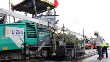 Nhà thầu tiến hành thảm nhựa lớp đầu tiên tại gói thầu số 21, thuộc dự án thành phần 1, đường cao tốc Biên Hòa-Vũng Tàu, đoạn qua tỉnh Đồng Nai. (Ảnh Công Phong)